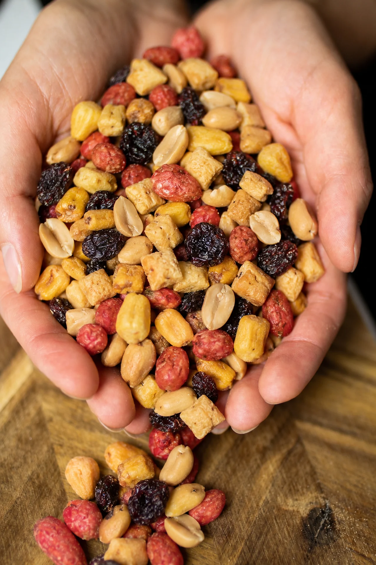 Hands presenting a colourful CrackersCompany snack mix